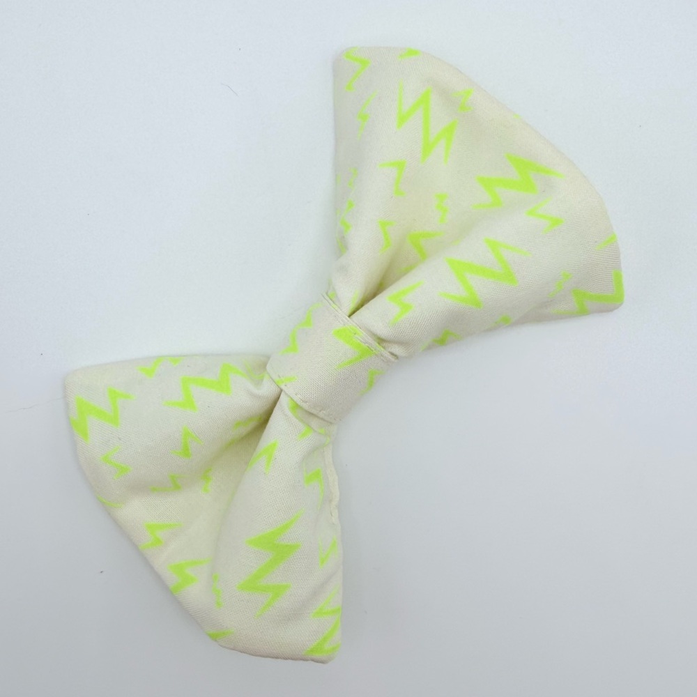 Cream colored handmade dog bow tie with neon yellow lightening bolts